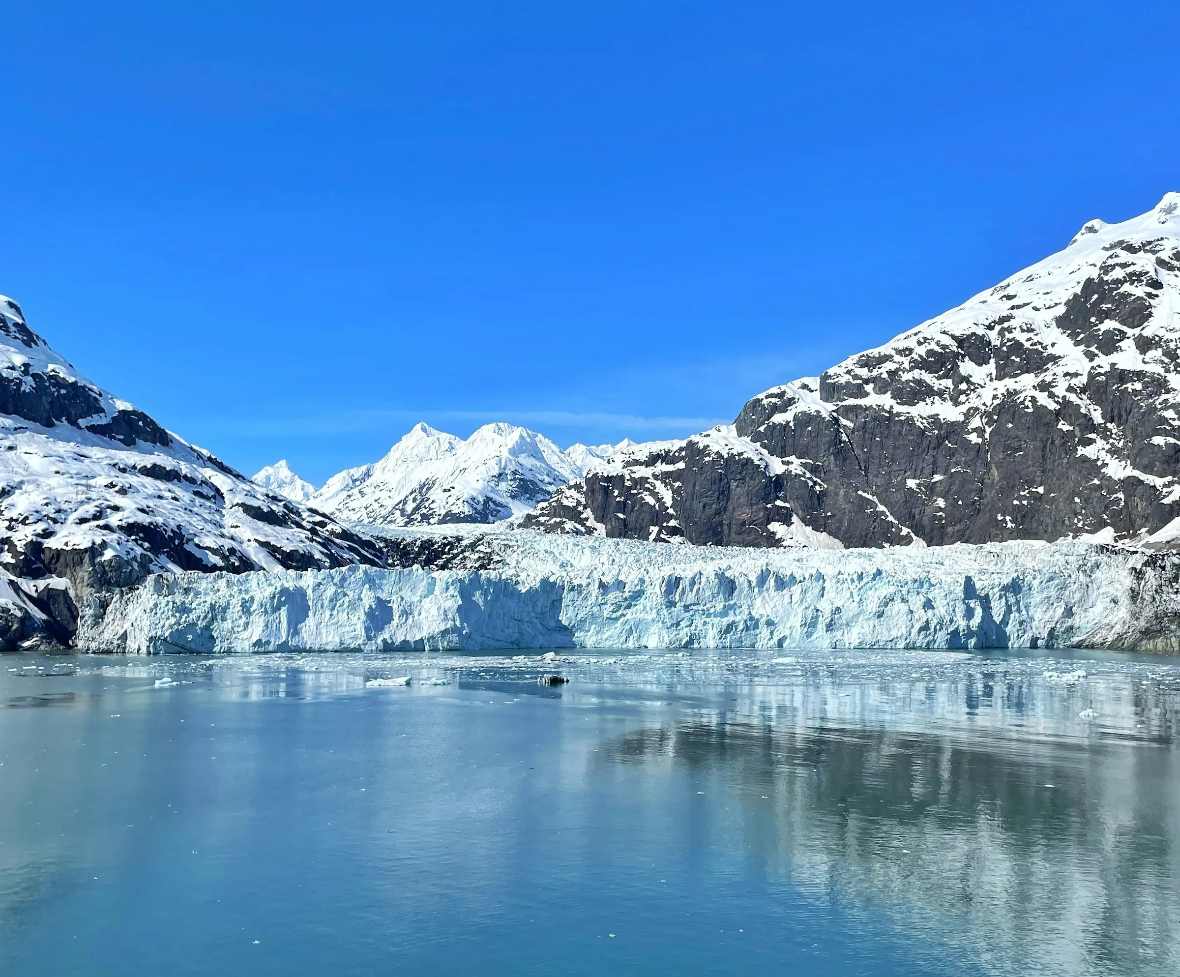 Glacier and snow peaks in Alaska under a blue sky