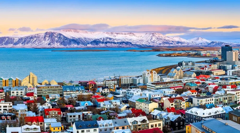 Coloured rooftops of Reykjavik below snowy mountains